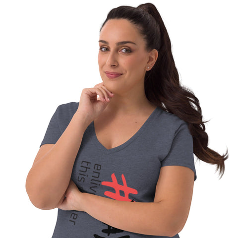 A woman with long dark hair tied in a ponytail wears the "Enliven" Women’s V-neck T-shirt by Magick, crafted from recycled fabric. The T-shirt is eco-friendly and features a vibrant hashtag design on a gray background. She stands confidently with a hand on her chin and a subtle smile, highlighting the elegance of this stylish garment.