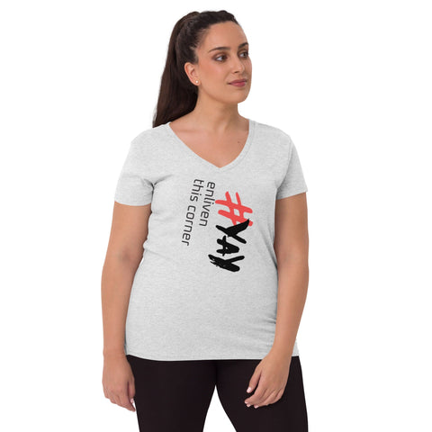 A person wearing an eco-friendly tee, the light gray "Enliven" Women's V-neck T-shirt by Magick, crafted from recycled fabric featuring the text "#YAY enliven this corner" in black and red. The individual has long dark hair, gazing to the side, complemented by dark pants.