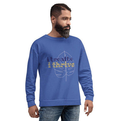 A bearded man with short hair is wearing a stylish and comfortable magickwear "Breathe" Unisex Lettering Sweatshirt. The blue garment, featuring the phrase "i breathe i thrive" in black and yellow text with a leaf graphic, is made from a durable fabric blend. He stands against a plain white background.