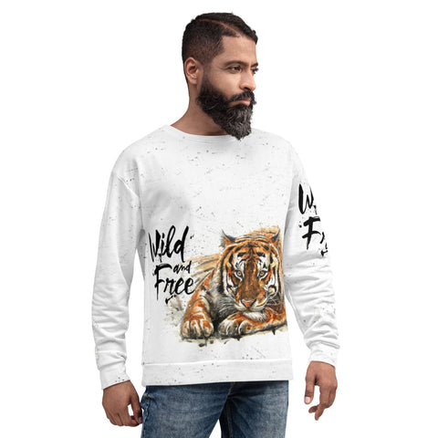 A bearded man with short hair is seen wearing the magickwear "Wild & Free" Unisex Sweatshirt, which features a realistic tiger illustration paired with the words "Wild & Free." He stands against a plain white background, one hand in his jean pocket, looking slightly to the side.