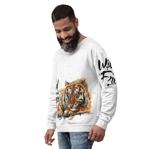 A bearded man smiles while wearing a white "Wild & Free" Unisex Sweatshirt by magickwear, which features a striking tiger graphic on the front and the words "Wild and Free" adorning the sleeves. Standing against a plain white background, dressed in blue jeans, he effortlessly showcases his comfortable yet stylish sweatshirt.