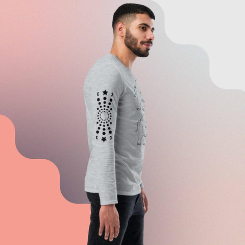 A bearded man wearing the "Carry On" unisex fashion long-sleeve shirt from magickwear, featuring graphic prints on the front and left sleeve, stands against a gradient background of soft peach and light gray hues. This versatile clothing item offers both comfort and style. The man is facing slightly to the right with a relaxed expression.