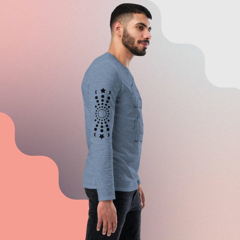 A man with short hair and a beard stands in profile, wearing a light blue "Carry On" long-sleeve shirt from magickwear. The shirt is eco-friendly, unisex, and features a black circular and star-like pattern on the left sleeve. The background showcases a split design with peach and white wavy elements. He has a relaxed and slight smile.