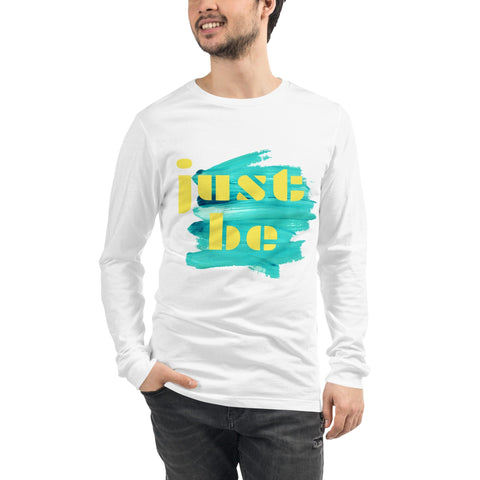 A man in the "Just Be ..." Unisex Lettering Tee by magickwear, featuring a colorful design with "just be" in yellow, smiles warmly with one hand in his pocket. This versatile tee provides both comfort and durability, making it a stylish choice for any occasion.