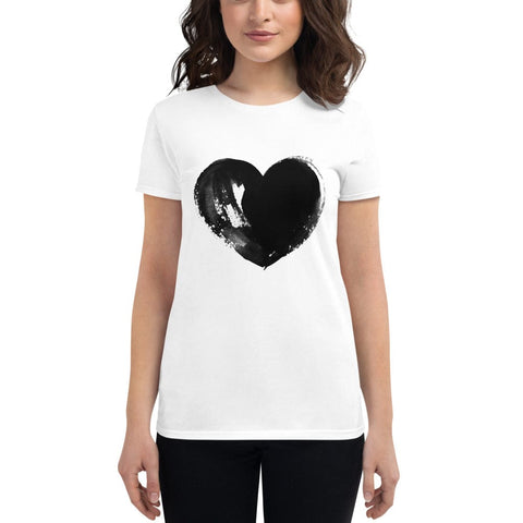 A person with shoulder-length dark hair is wearing a stylish tee from magickwear, specifically the "Full Heart" Tee, which features a large black abstract heart design in the center. They are standing against a plain white background.